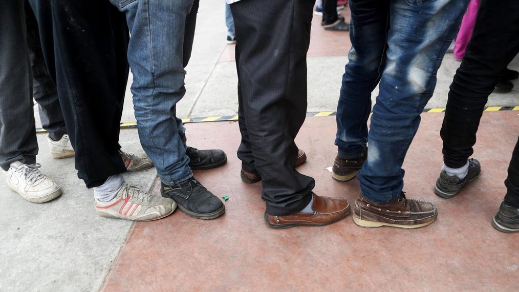 Asylum seekers wait in line to be processed in this file photo.