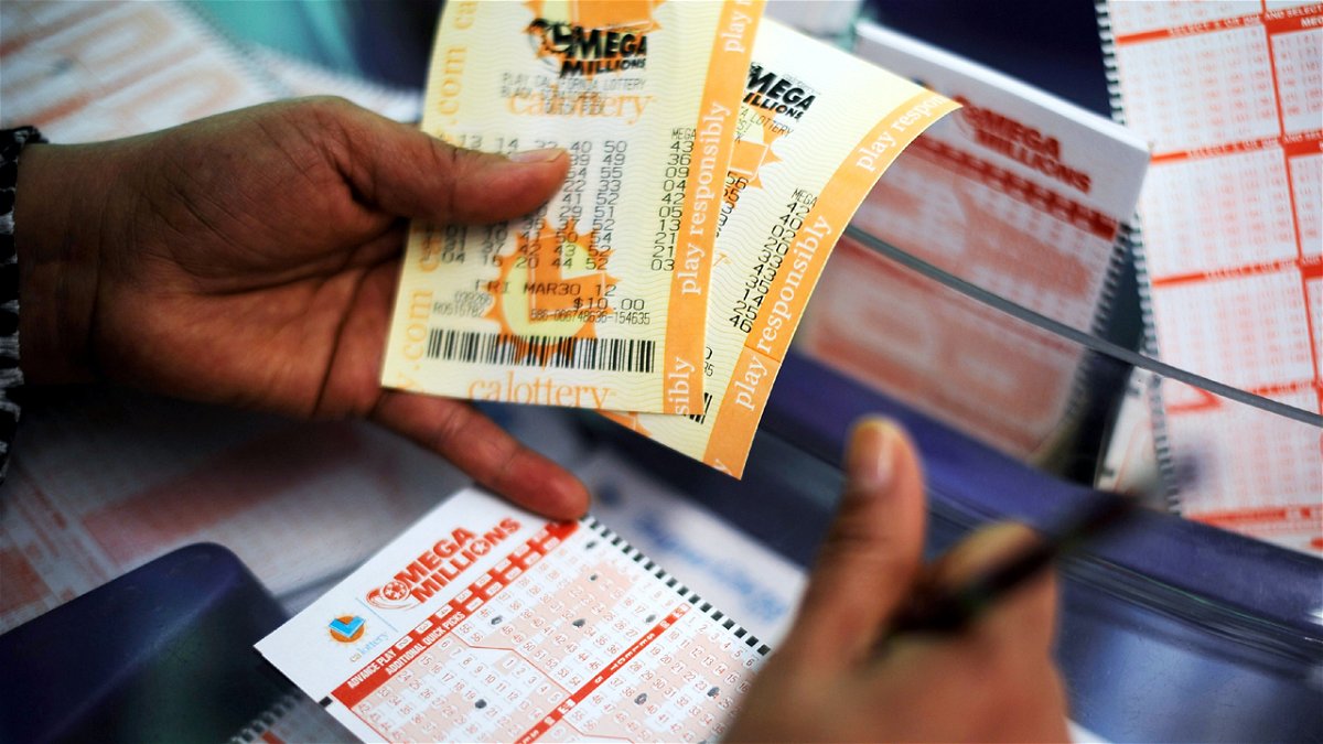 A man hold Mega Millions tickets in his hand.