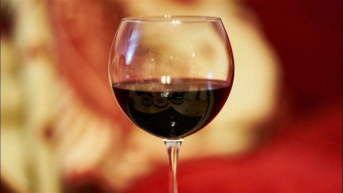 A glass of red wine after being poured.