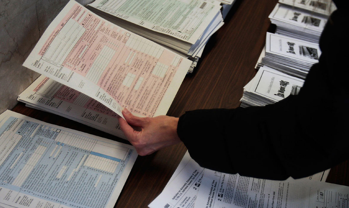 A woman picks up income tax forms.