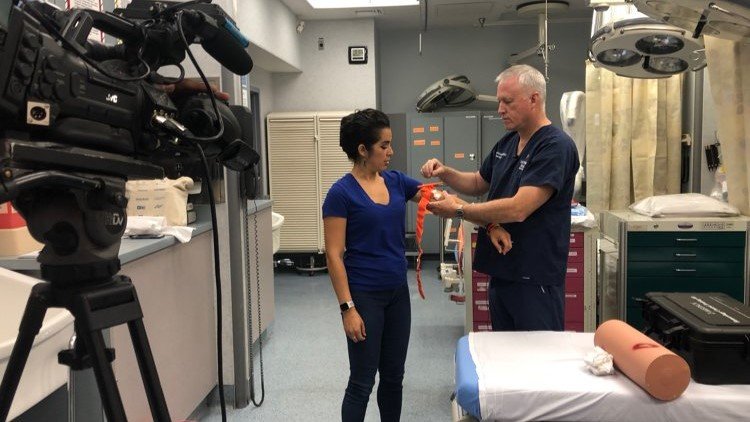 Dr. Stephen Flaherty demonstrates proper tourniquet application for ABC-7 anchor Stephanie Valle