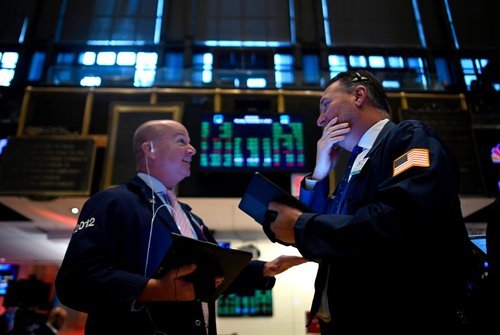 Traders monitor the Dow Jones Industrial Average at the New York Stock Exchange.