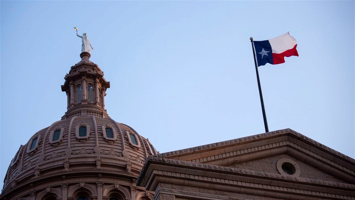 The state flag flies over the Texas State Capitol.