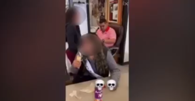 Image from video that seemingly shows a male teacher slap the buttocks of a female student.