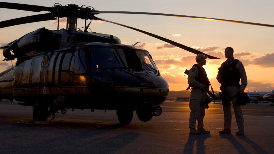 A pair of Customs and Border Patrol UH-60 Black Hawk pilots get ready in the early morning to conduct patrols.