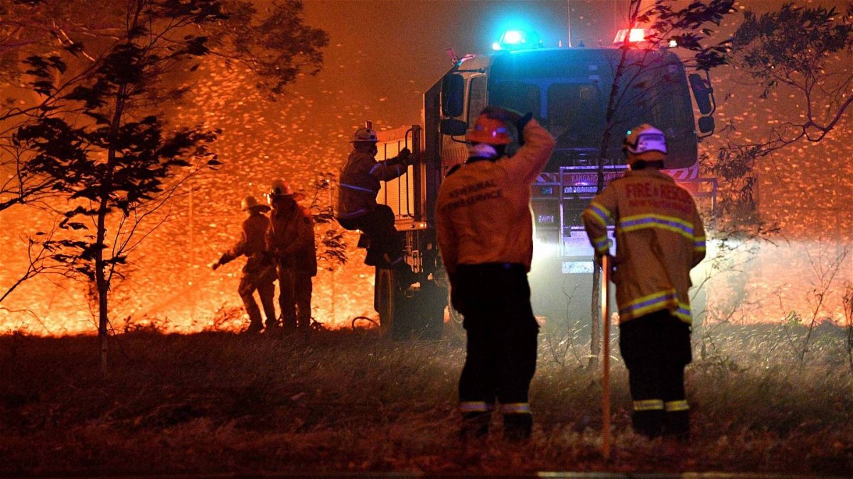 Firefighters hose down trees as they battle against bushfires around the town of Nowra in the Australian state of New South Wales.