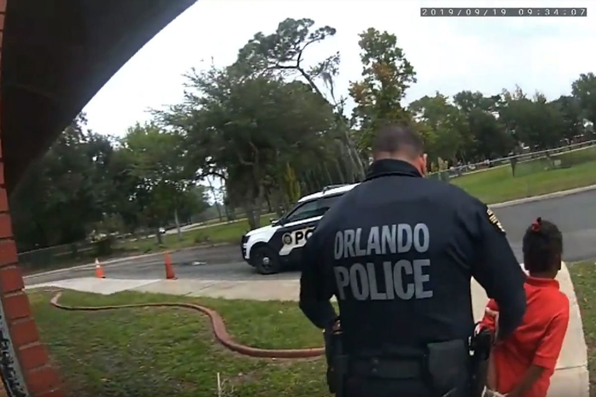 Orlando Police Officer Dennis Turner leads 6-year-old Kaia Rolle away after her arrest for kicking and punching staff members at school.