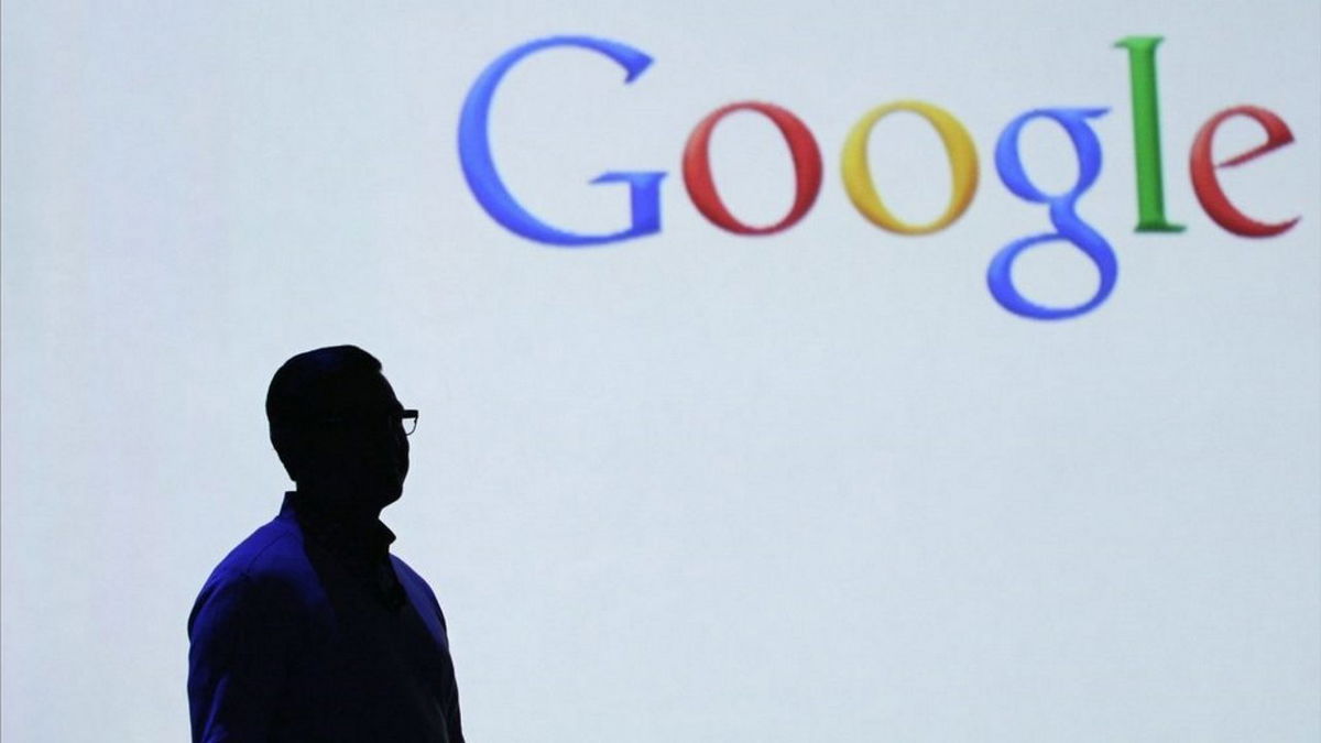 A worker stands beneath the Google logo at the company's headquarters.