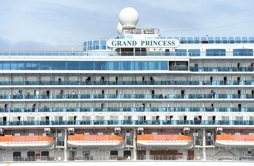 Passengers look out from aboard the infected Grand Princess cruise ship.