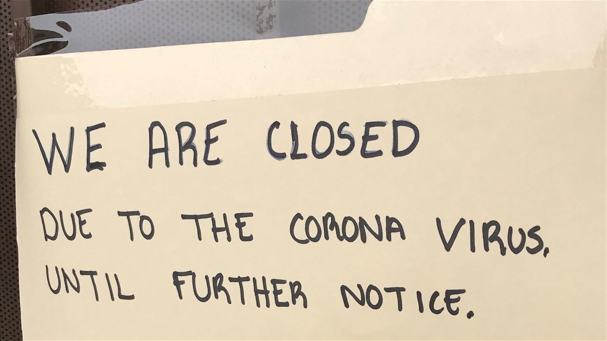 Handwritten closed sign on the front door of the El Paso Cotton Association.