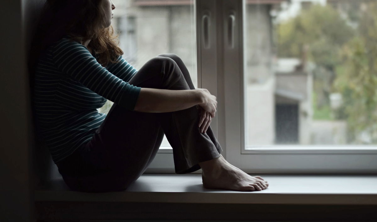 A sad woman stares out a window in this file photo.