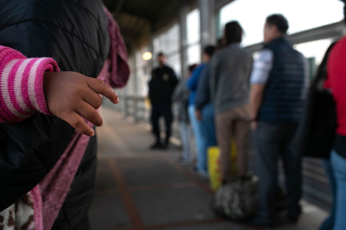 Asylum seekers wait on the international bridge from Mexico to the United States next to the border town of Matamoros, Mexico.