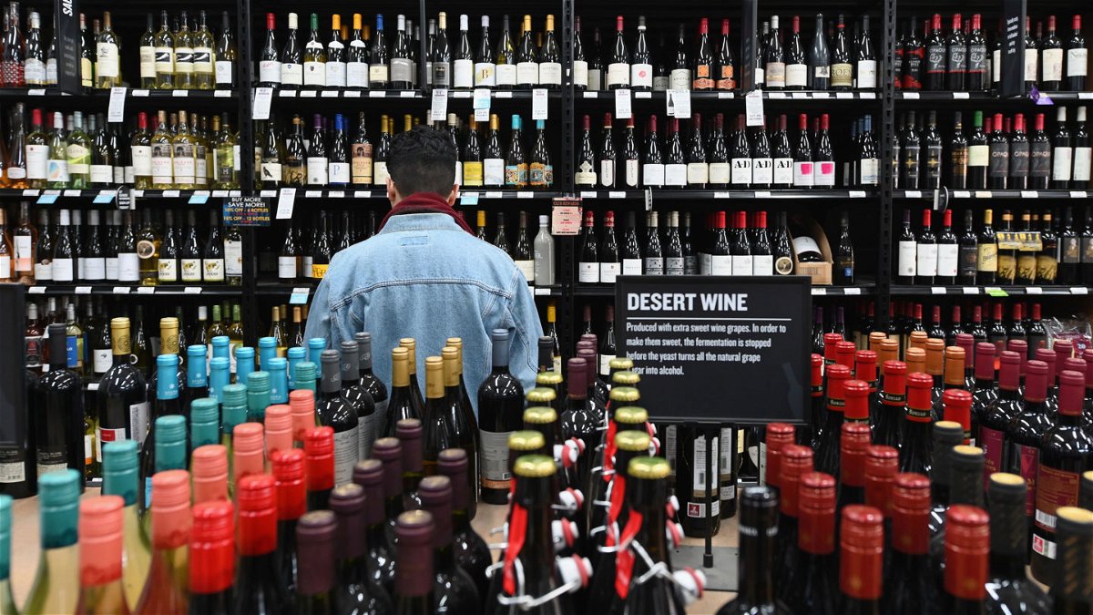 A patron stands in front of a shelf full of wine bottles at a liquor store in this file photo.