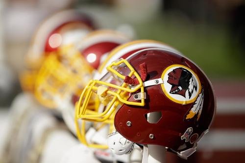 Washington Redskins helmets are arranged in a display.