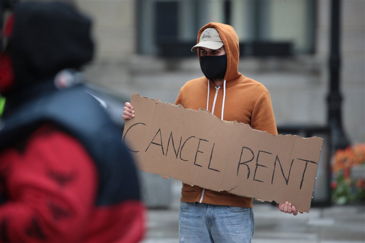 A renter who needs help holds a sign saying 