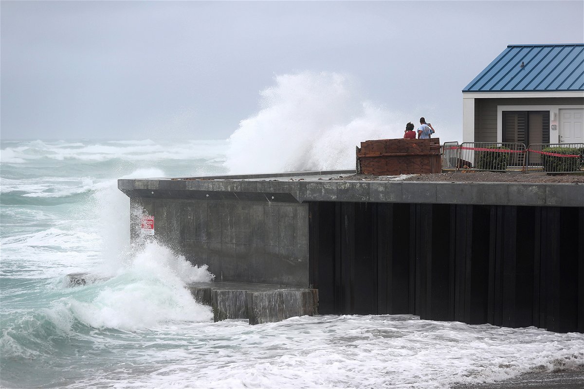 A wave crashes ashore next to a building in Juno Beach, Florida. 