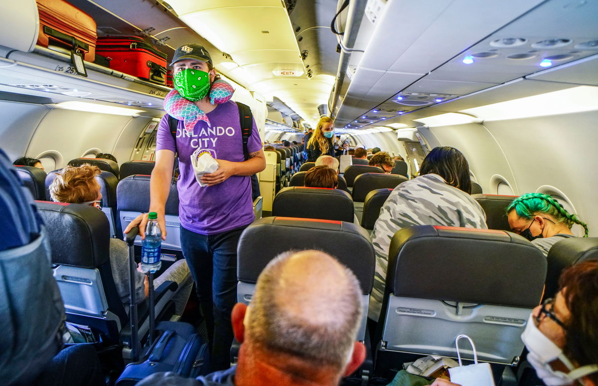 Passengers board an American Airlines flight wearing masks.