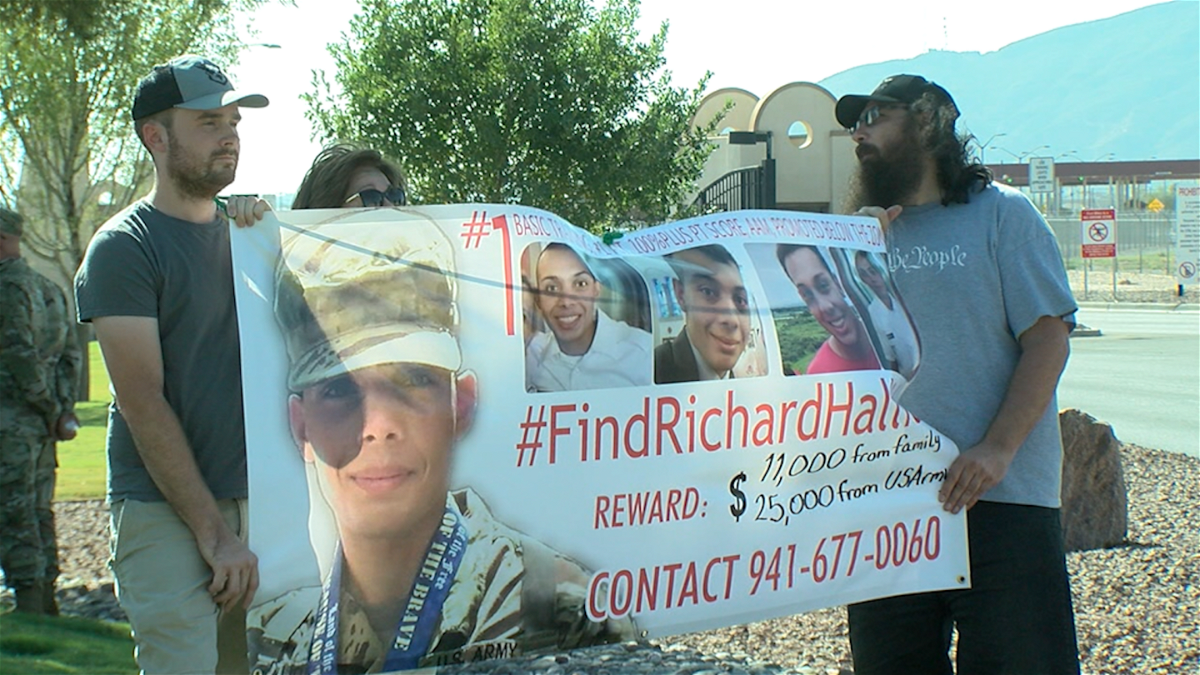The family of missing soldier Richard Halliday holds a banner outside Fort Bliss.