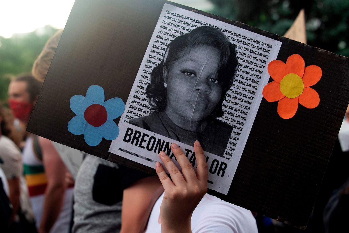 A demonstrator holds a sign with the image of Breonna Taylor, a black woman who was fatally shot by Louisville officers.