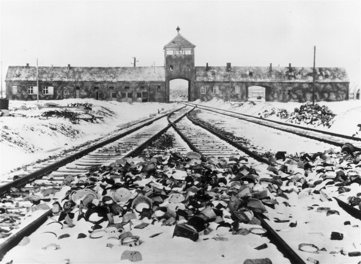 Snow-covered personal effects of those deported to the Auschwitz concentration camp in Poland litter the train tracks leading to the camp's entrance in 1945. 