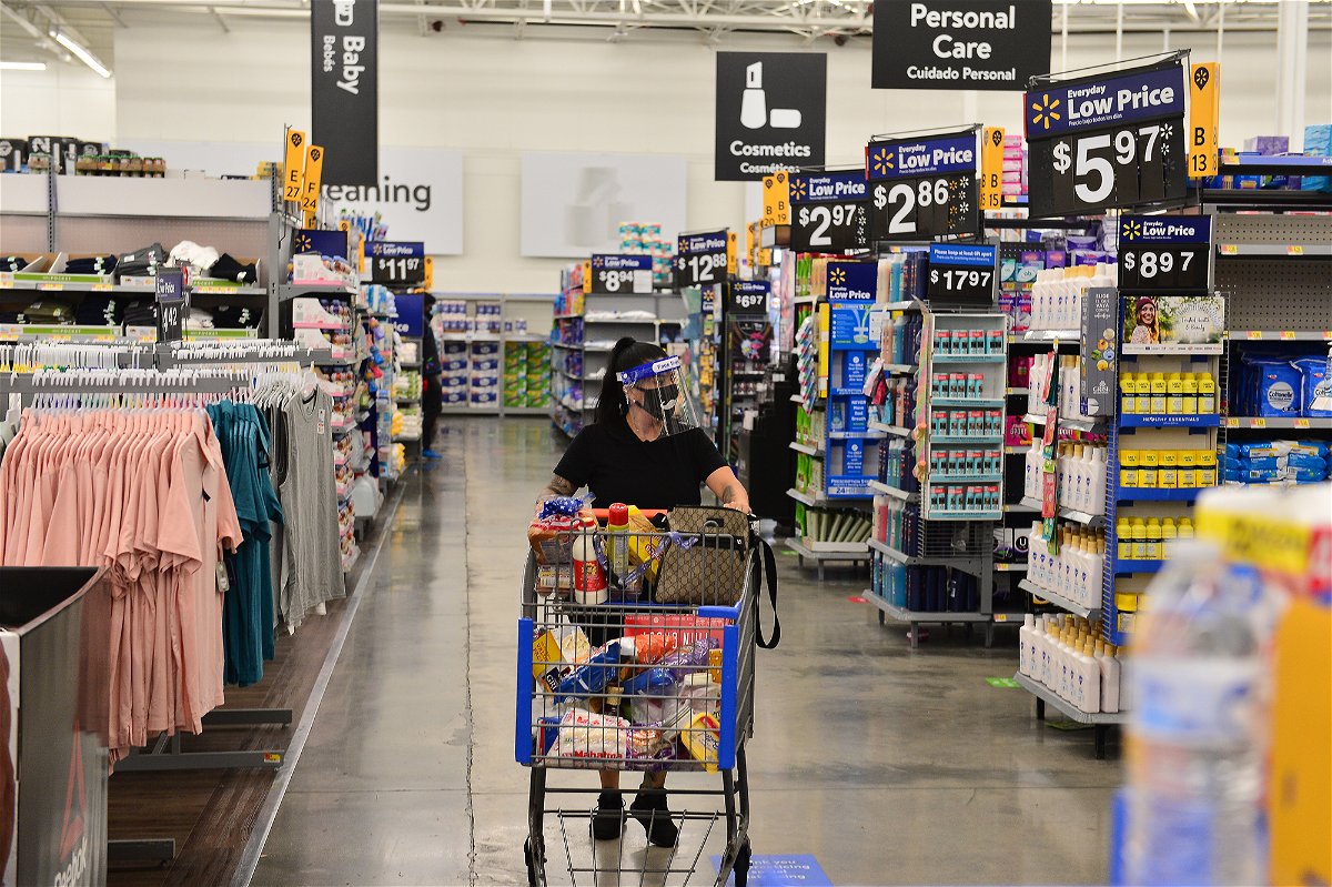 Customer wearing a face shield shops at a Walmart store .