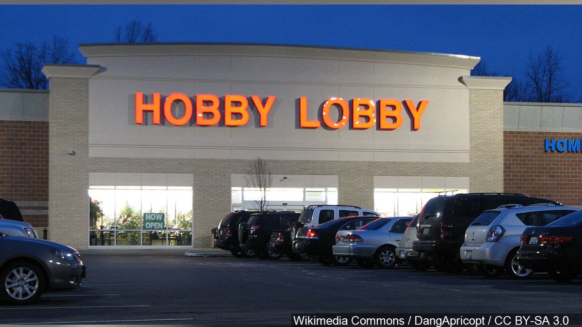 Cars parked in the lot in front of a Hobby Lobby store.