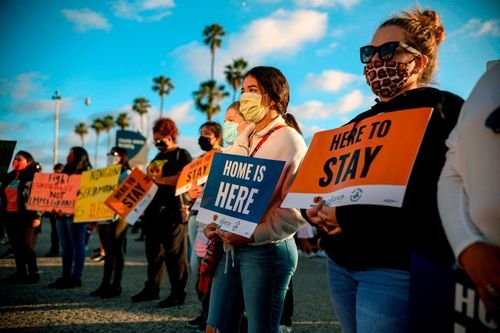 People hold signs during a rally in support of the Deferred Action for Childhood Arrivals (DACA) program, in San Diego.