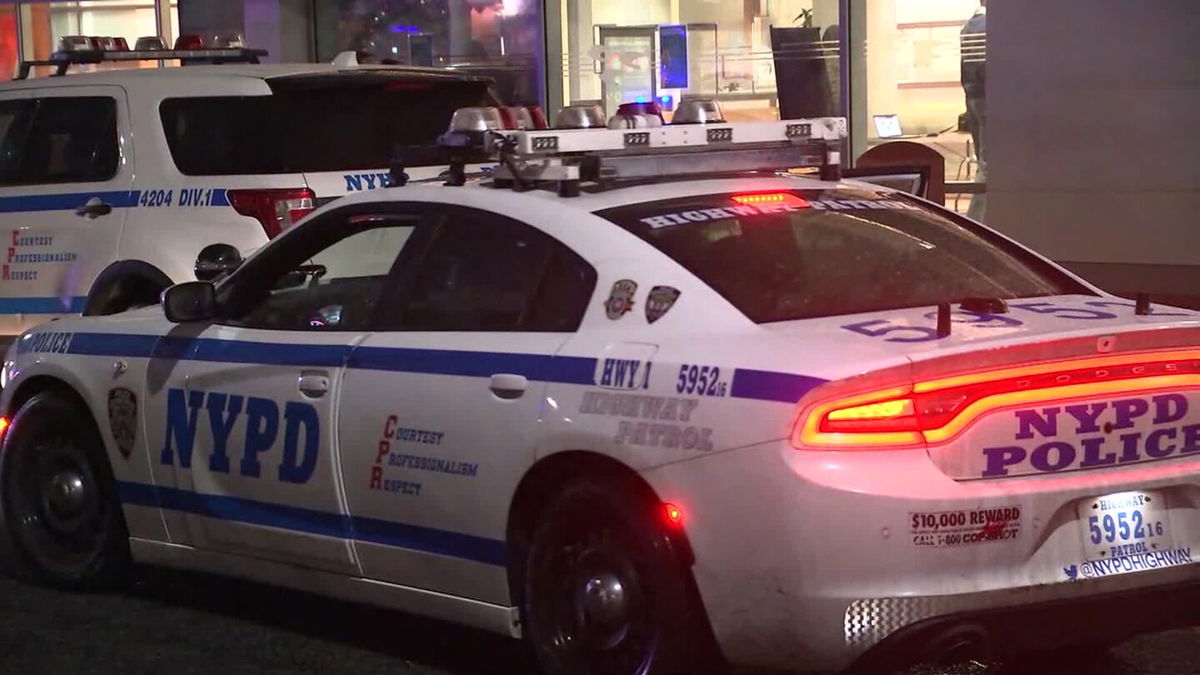 An NYPD squad car sits parked at a crime scene.