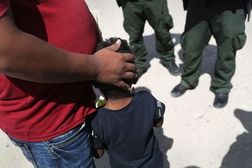 Border Patrol agents with a migrant and his child in Mission, Texas.