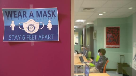 A sign telling those who enter that masks and social distancing are required.