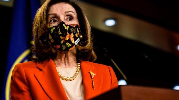 U.S. House Speaker Nancy Pelosi wearing a mask while speaking with reporters.