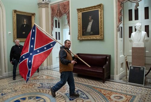 man carrying Confederate flag