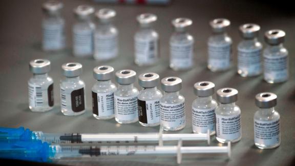 Vials of Pfizer coronavius vaccine and syringes sit on display.