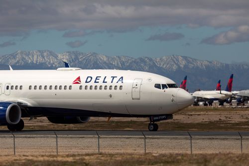 A Delta Airlines flight sits on a runway in California.