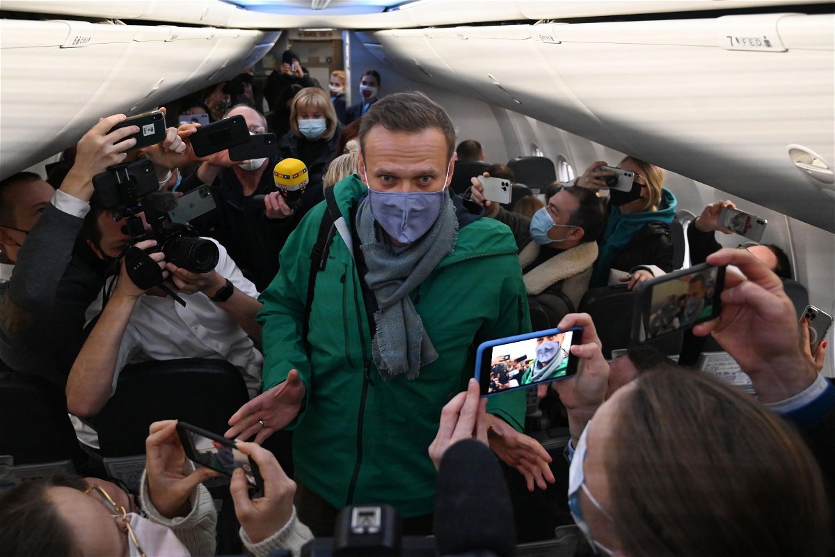 Russian opposition leader Alexei Navalny walks to take his seat on a Pobeda airlines plane heading to Moscow 