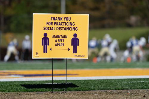 A sign outside promoting social distancing.