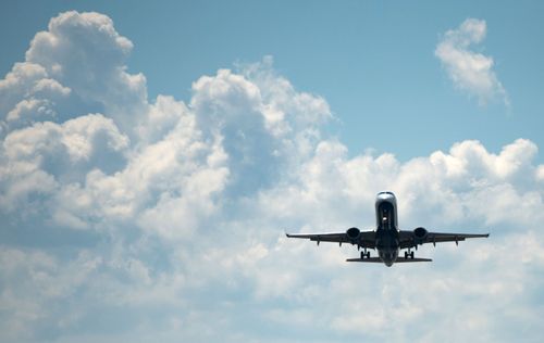 A plane flies in the sky after takeoff from an airport.