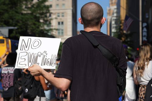 A man holds a sign saying 