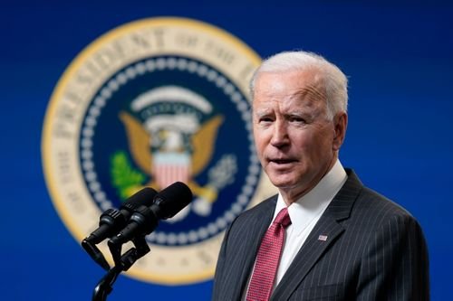 President Biden speaks amidst the backdrop of the presidential seal.