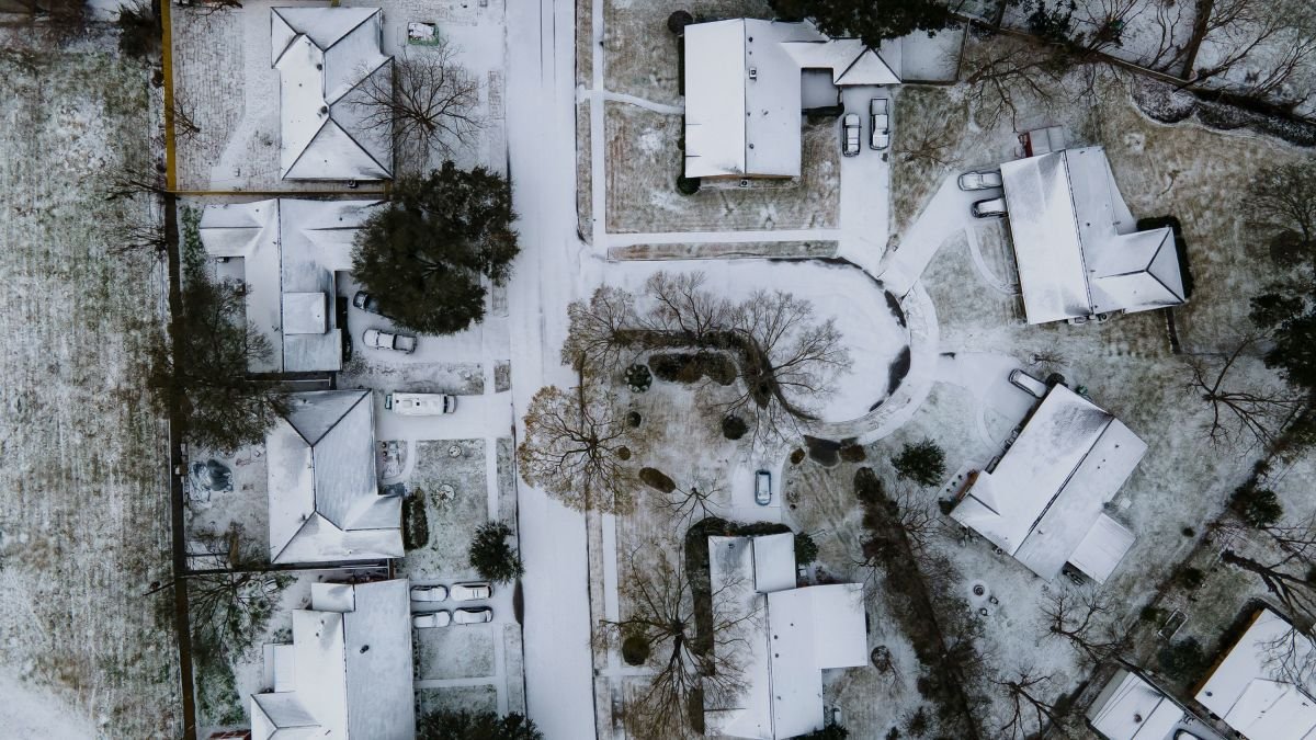 An aerial view of storm-battered homes in Houston covered in snow.