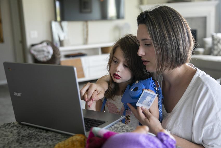 A Texas mother helps her daughter will school work on the computer.