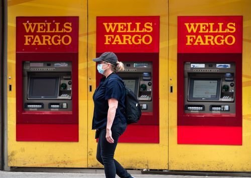 A woman walks by Wells Fargo bank ATM machines.