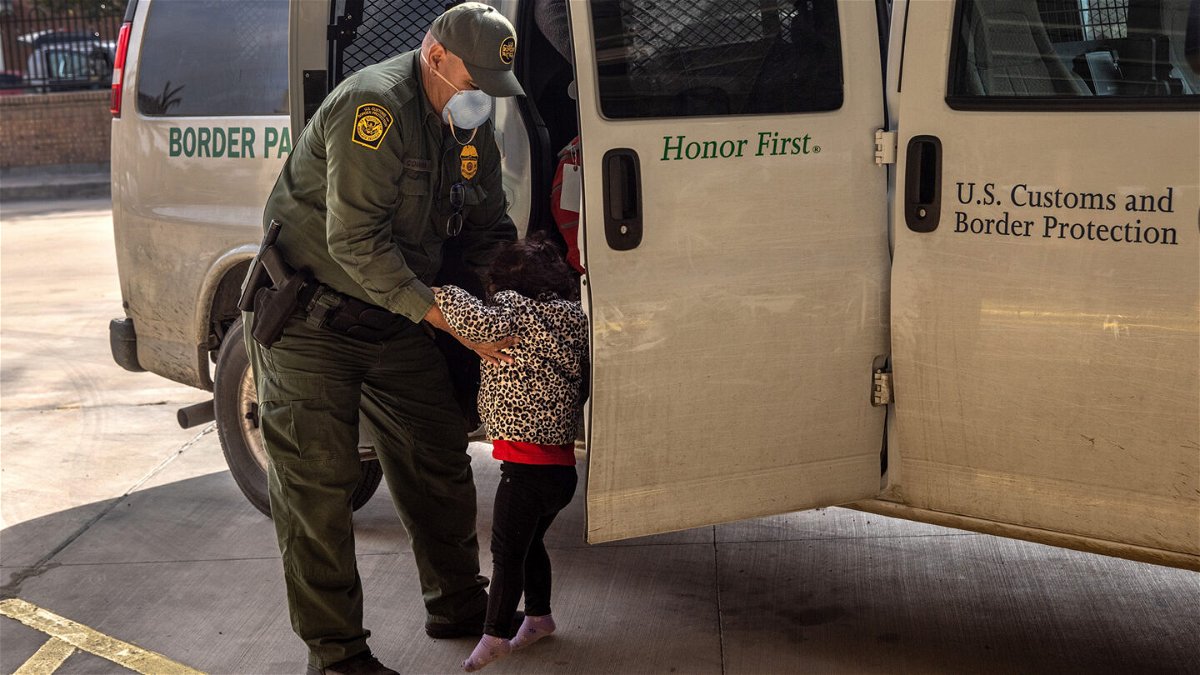 A U.S. Border Patrol agent releases a young asylum seeker with her family at a bus station n Brownsville, Texas. 