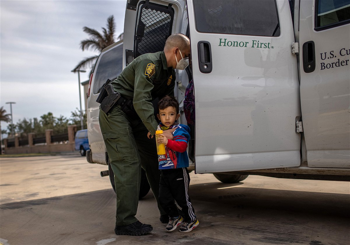 A U.S. Border Patrol agent delivers a young asylum seeker and his family to a bus station in Brownsville, Texas. 