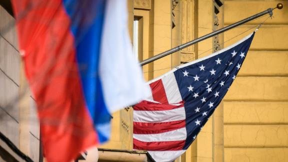 The Russian flag and the U.S. flag flap in the wind.