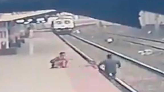 CCTV shows the moment a railroad worker snatched a child from the path ...