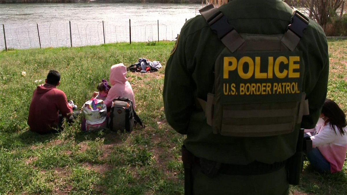 A US Border Patrol agent in the Rio Grande Valley looks over migrant families.
