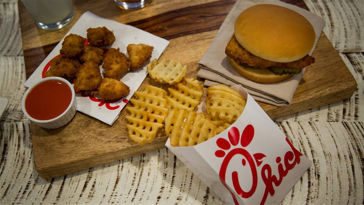 Chicken nuggets with sauce, french fries, and a fried chicken sandwich are displayed at a Chick-fil-A restaurant.