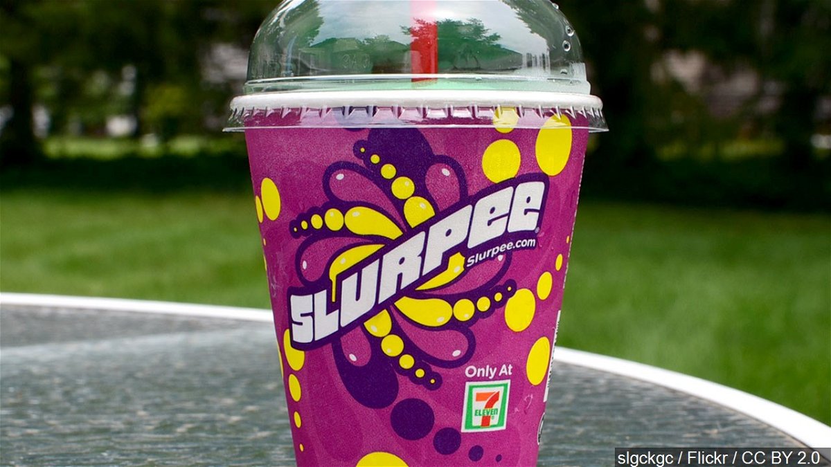 A slurpee from 7-11 sits on a backyard table.
