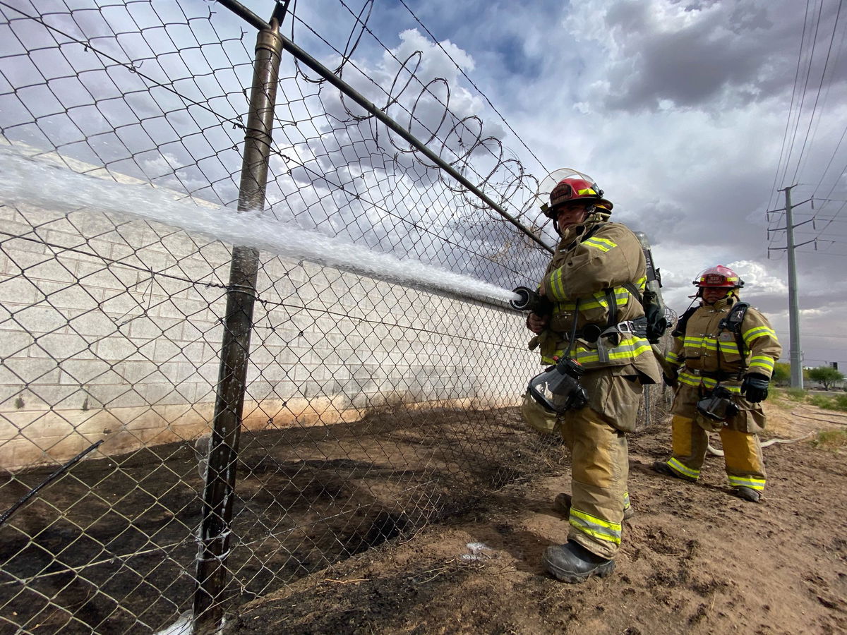 Firefighters battle a brush fire outside a Lower Valley warehouse.